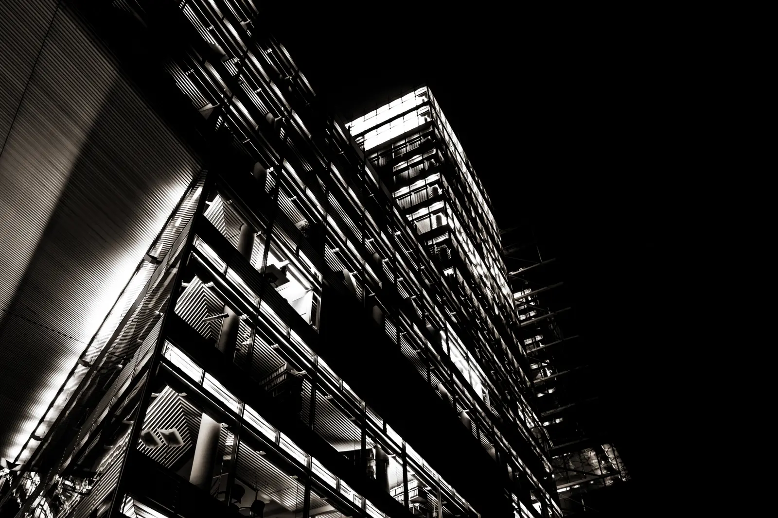 Schwarzweiß: Untersicht auf eine Stahl-Glas-Fassade.
