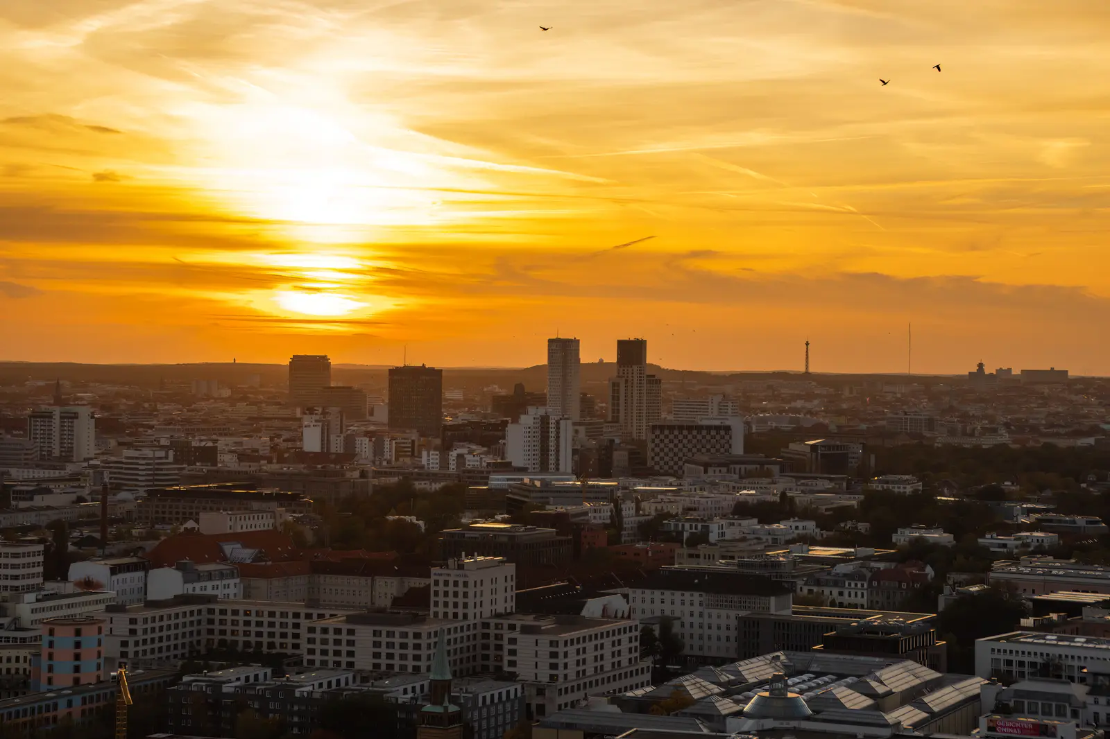 Sonnenuntergang über der Berliner Skyline, ein Wolkenband liegt über der Stadt.