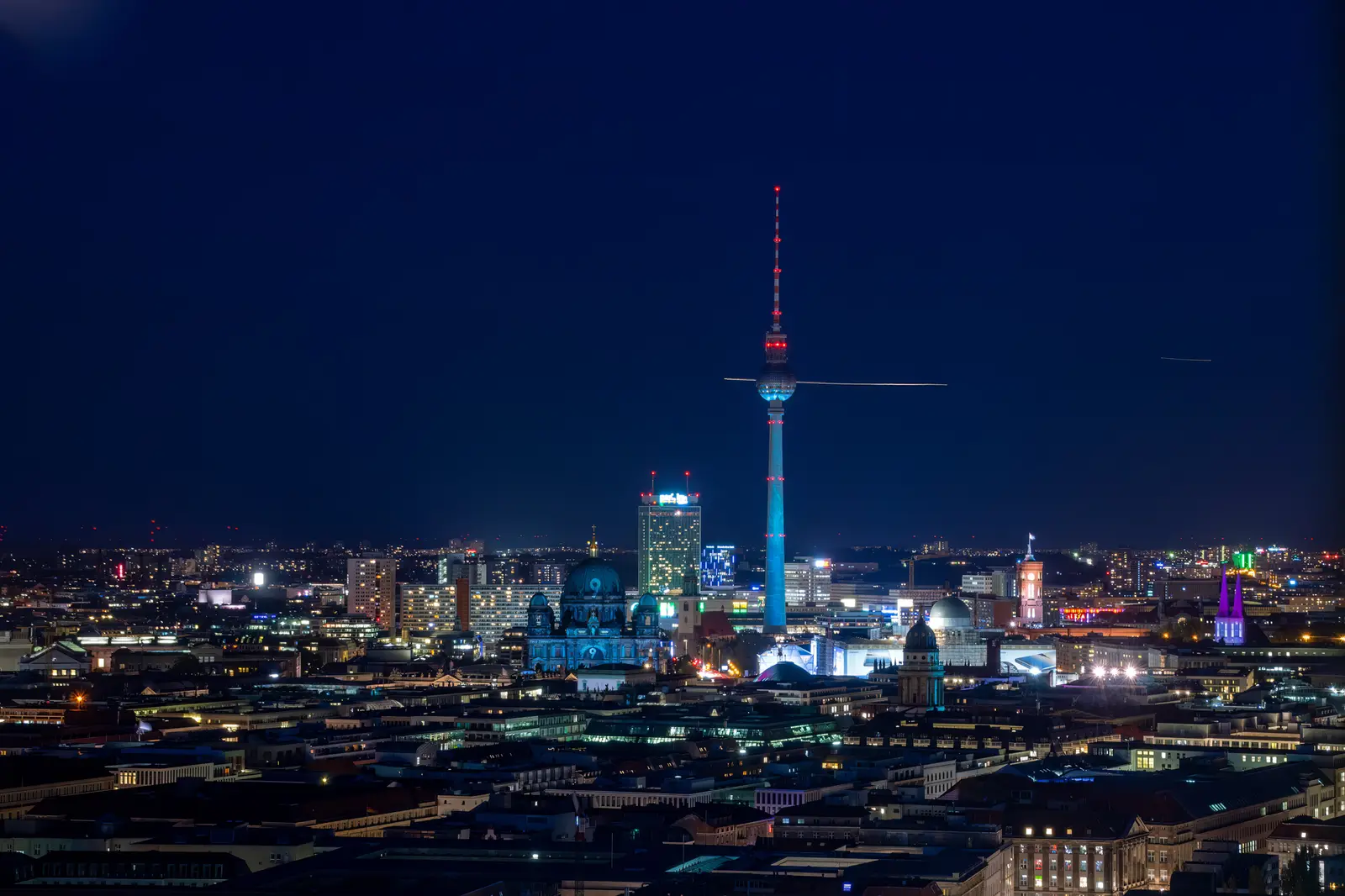 Fernsehturm und beleuchtete Innenstadt in der blauen Stunde.