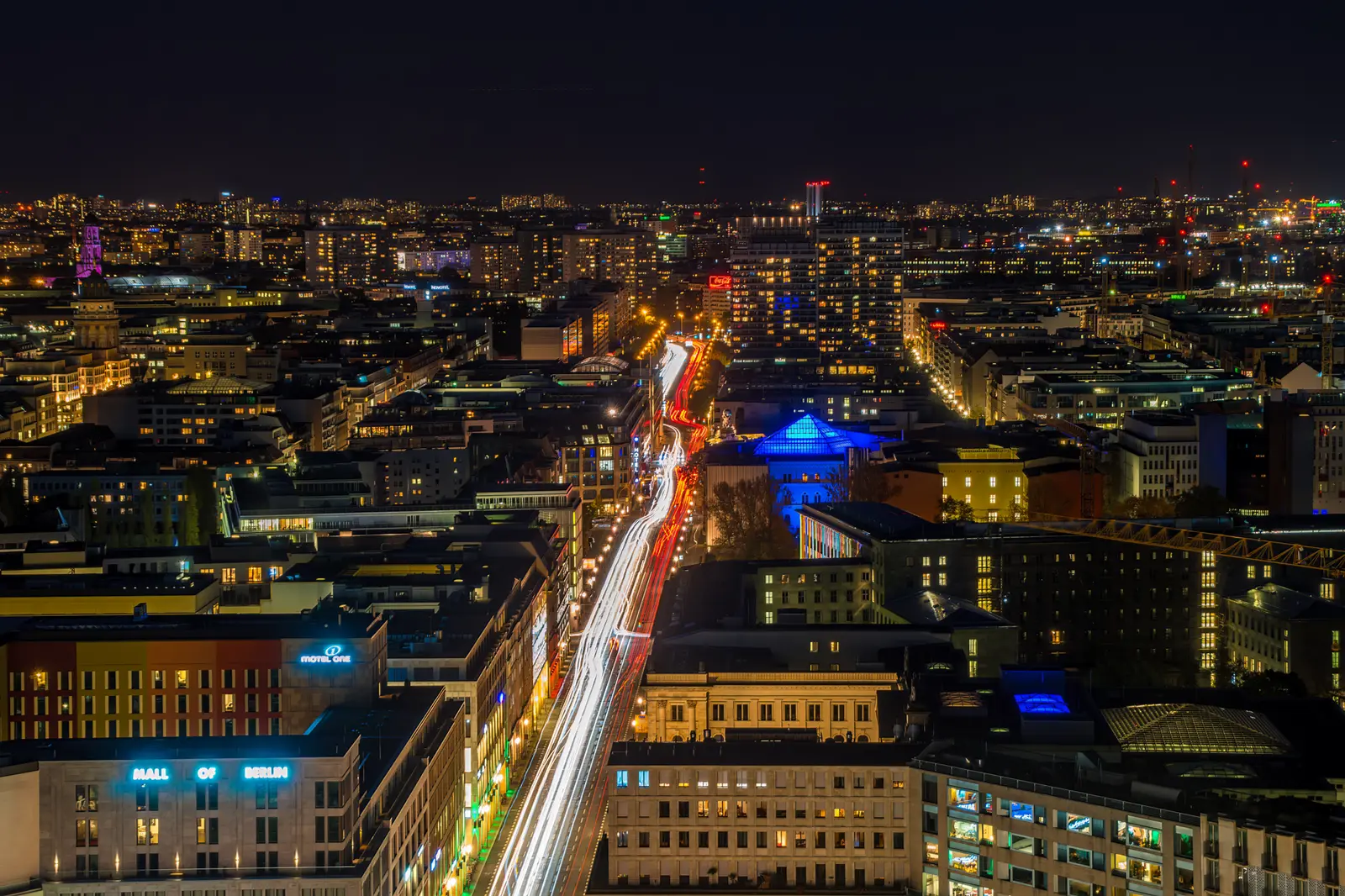 Blick über die nächtliche Stadt mit hell beleuchteten Straßenzügen.